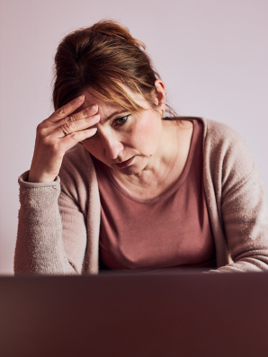 Fatigued woman in soft pink sweater—compassion fatigue awareness for caregivers and recovery tips.