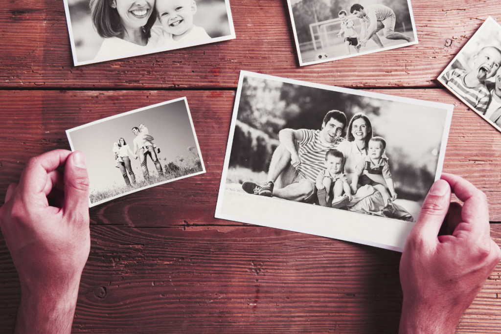 Caregiver sorting through printed family photographs, symbolizing preserving loved ones’ stories and keeping family memories safe with Forever.